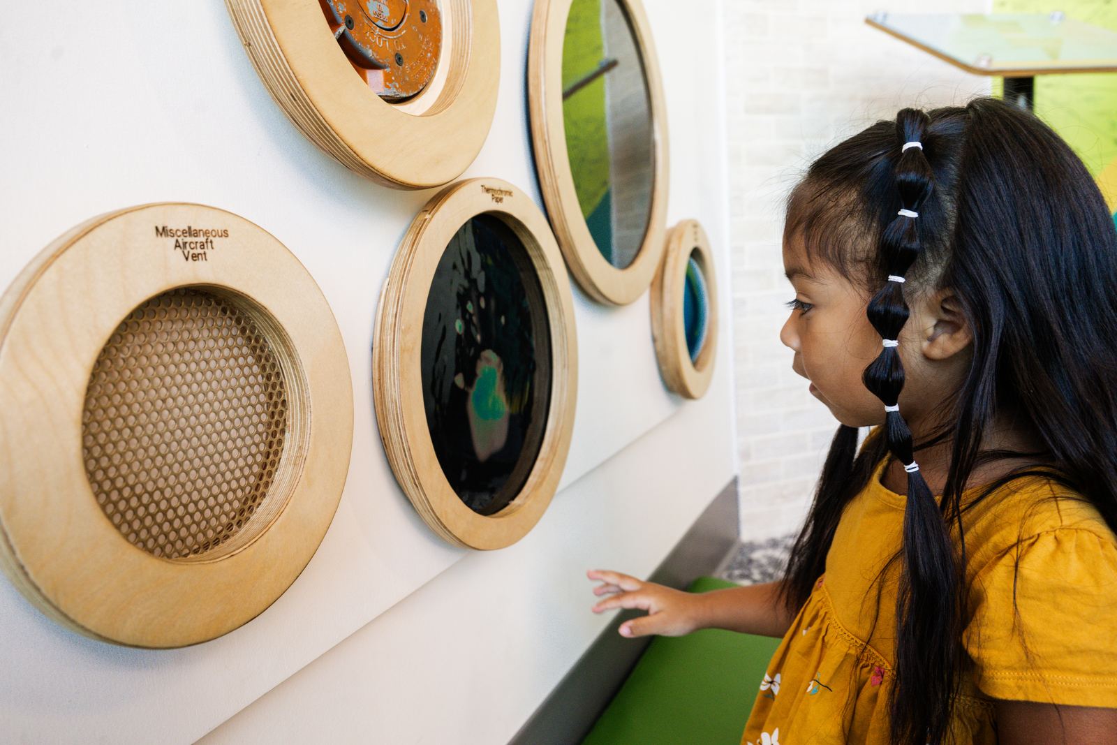 A young visitor exploring the porthole discovery panels